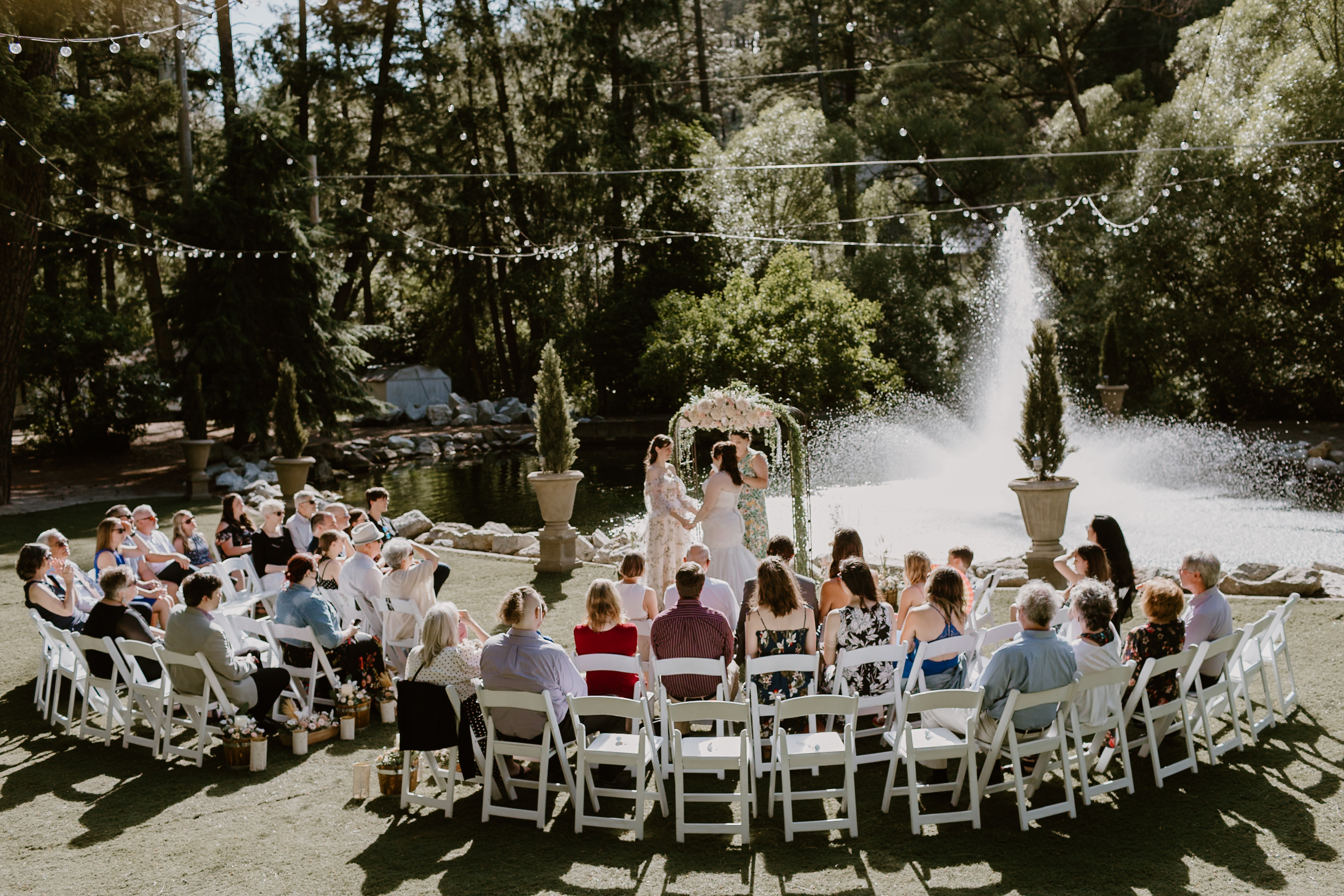 two brides getting married at commellini estate in front of the fountain