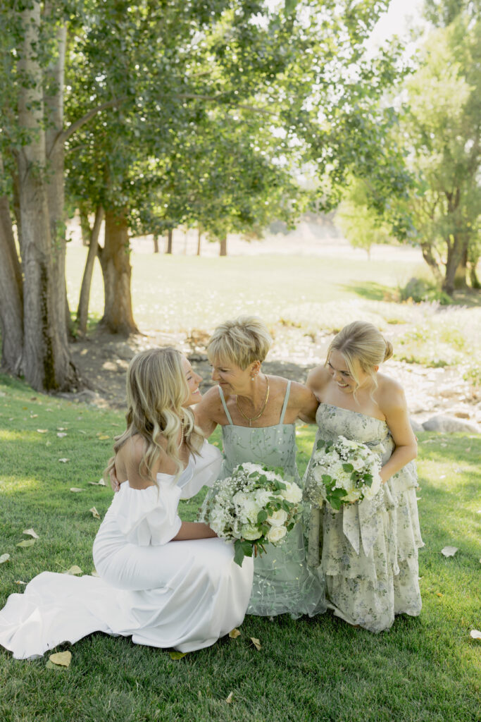 a bride, her mom and her sister in wedding outfits