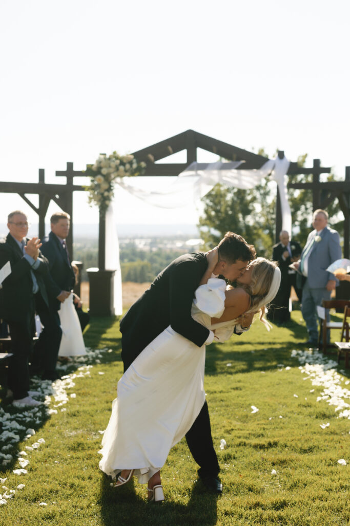 bride and groom kissing at the end of the aisle