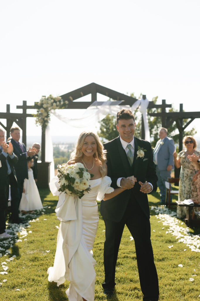 bride and groom walking back down the aisle celebrating