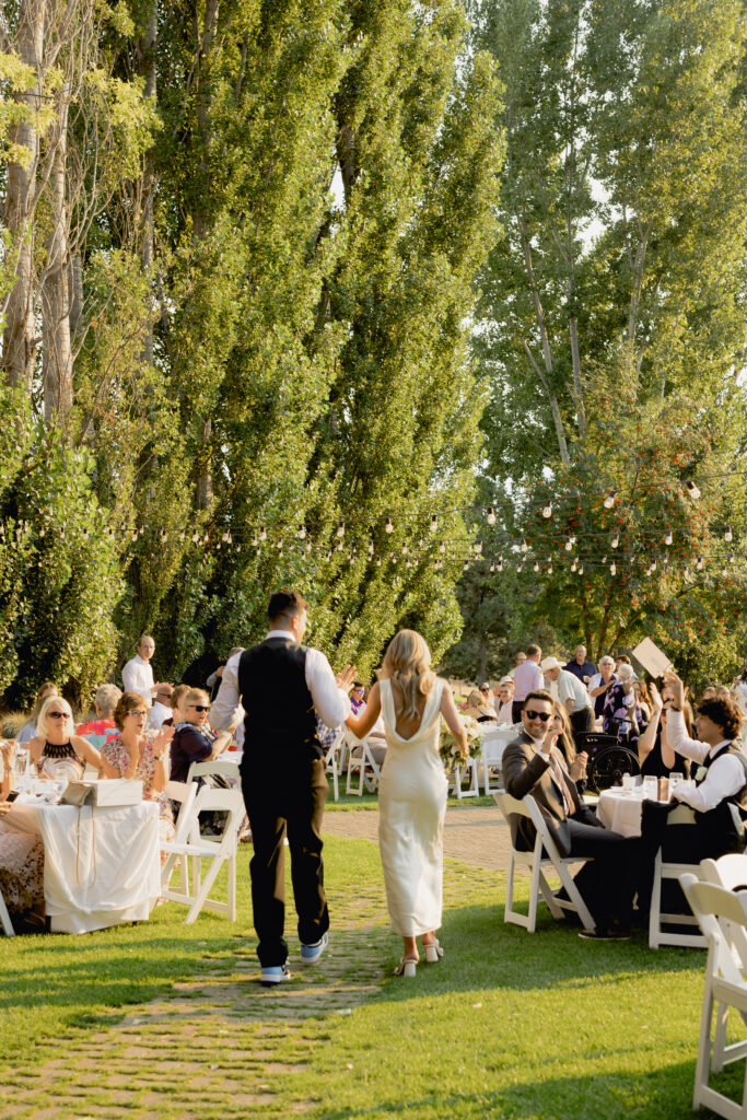 bride and groom walking into reception