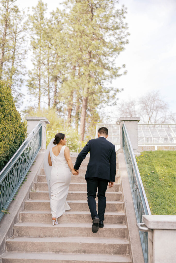 Bride and groom holding hands walking up the steps at Duncan Gardens in Manito Park in Spokane.