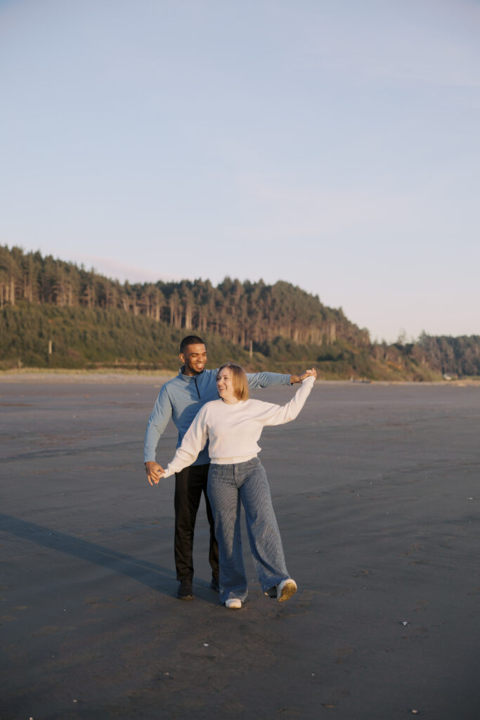 Engaged couple dancing and laughing together at golden hour