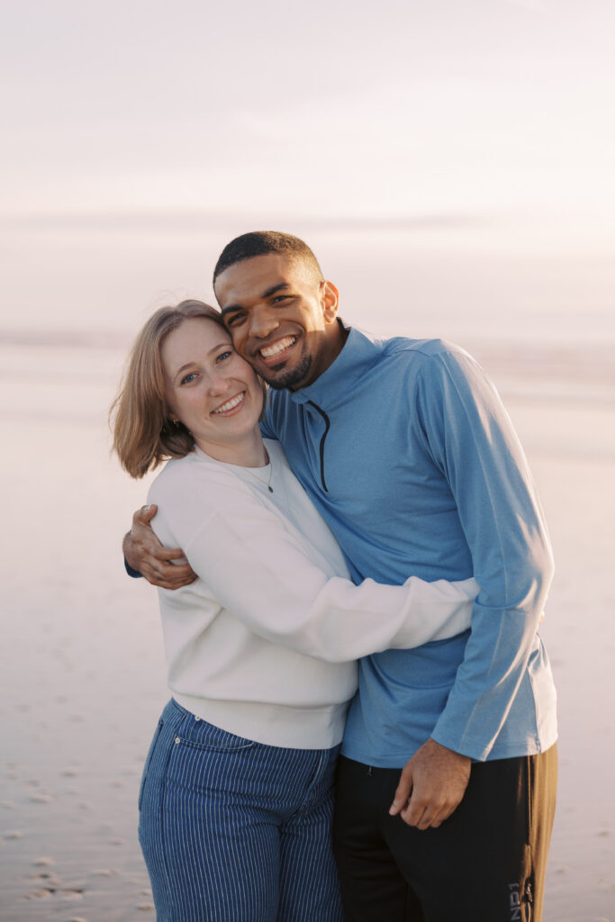 Julia and A'lon smiling at the camera during their Seabrook, WA engagement photos