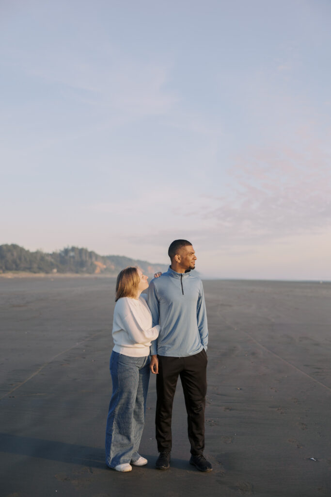Julia and A'lon looking out at the Pacific Ocean during their Seabrook engagement session